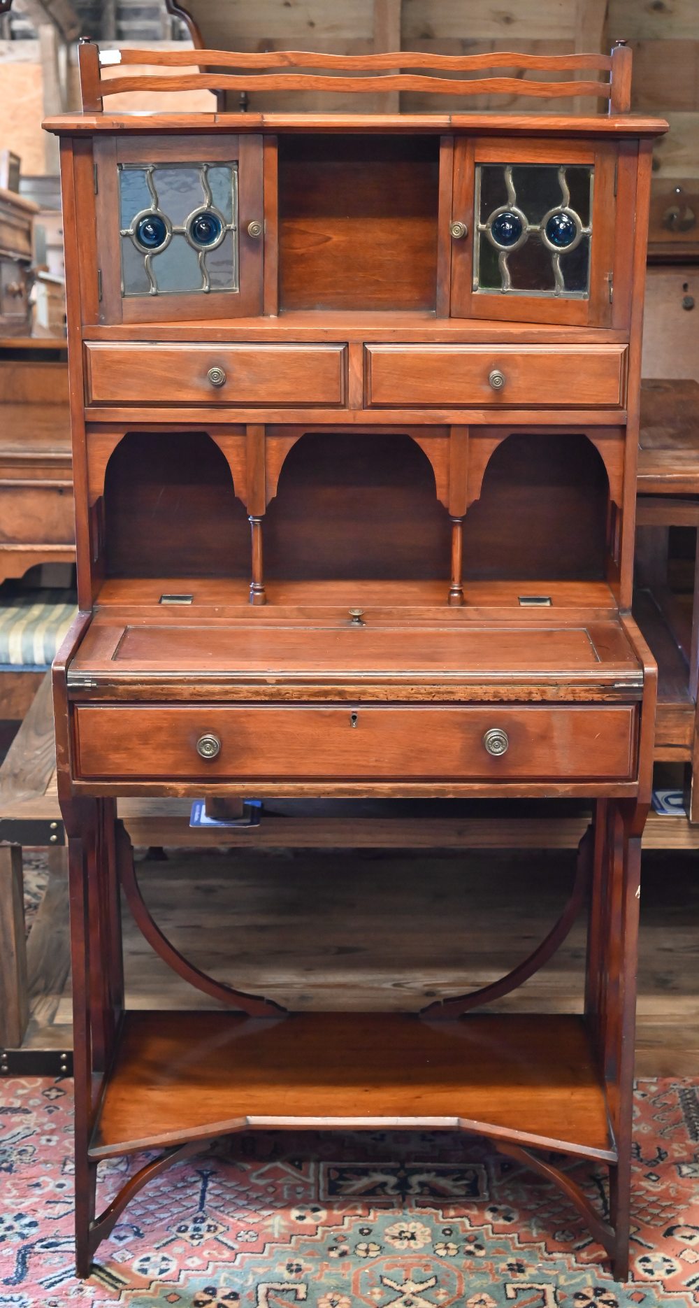 A 20th century Liberty style Arts & Crafts writing desk with leaded stained glass doors, three - Image 4 of 4