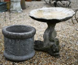 A cast stone scallop shell form bird bath raised on a dolphin base, weathered, 48 cm h to/with a
