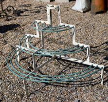 An antique wrought iron graduated three tier demi-lune plant stand, later painted, 109 cm w x 54