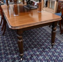 A Victorian mahogany wind-out extending dining table with two leaves, raised on turned and fluted