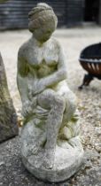 A weathered cast stone garden figure of a classical seated nude woman, 60 cm h
