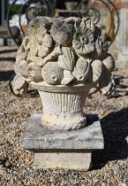 A weathered cast stone garden basket of fruit form finial