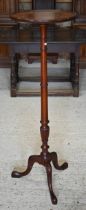 A mahogany jardiniere stand on turned column and triform supports, 40 cm dia. x 122 cm h