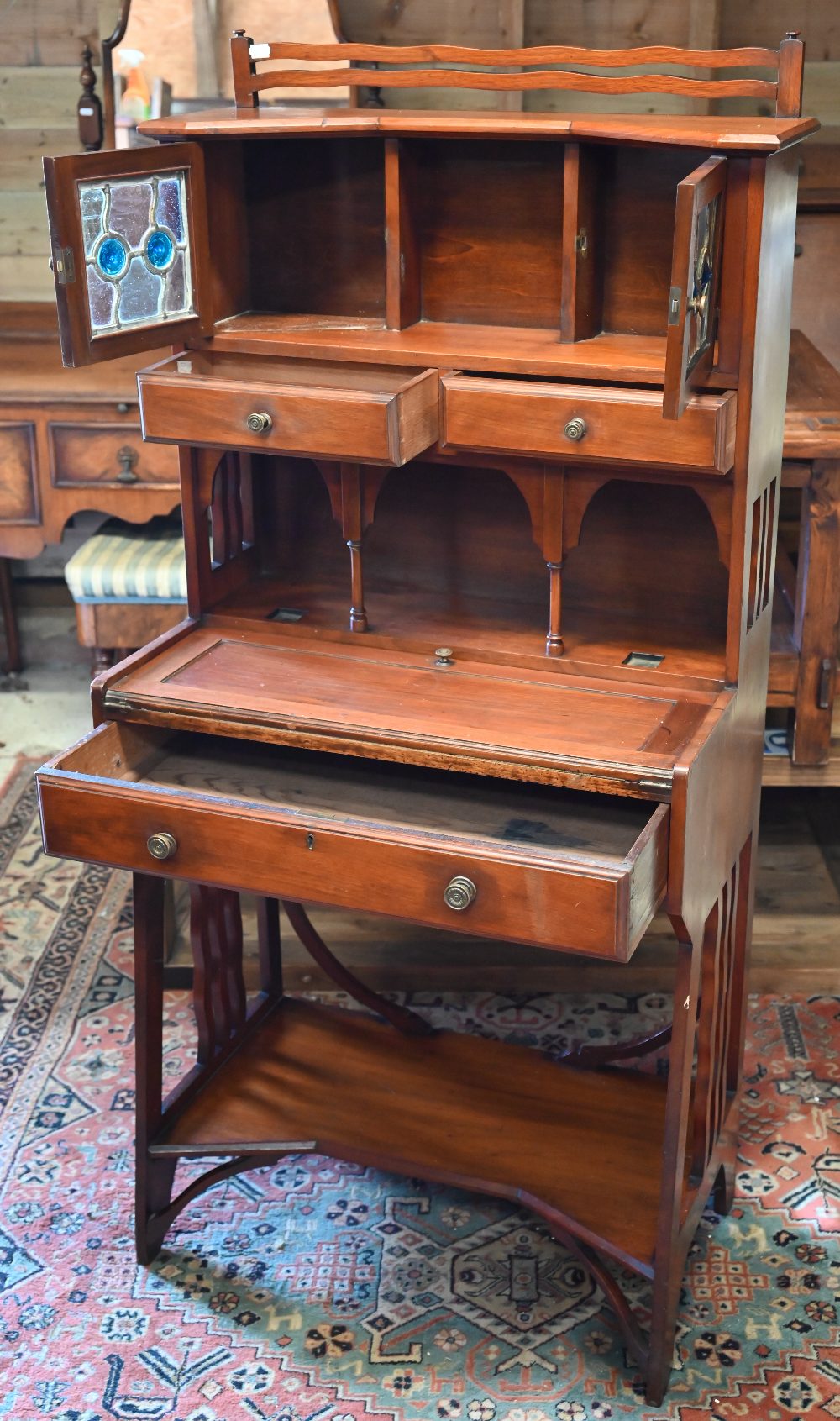 A 20th century Liberty style Arts & Crafts writing desk with leaded stained glass doors, three - Image 3 of 4