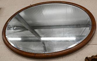 An Edwardian bevelled oval mirror in inlaid walnut frame, 103 cm wide x 78 cm high
