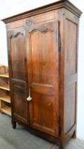 An antique French chestnut armoire with twin-panelled doors enclosing brass hanging rail (original