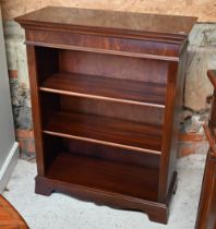 A reproduction bright mahogany open three tier bookcase, on a wavy plinth base, 82.5 cm w x 37 cm