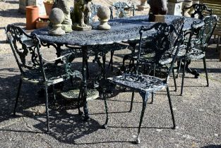 A Victorian style cast alloy terrace dining table and set of eight chairs, all in weathered green