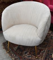 A modern bedroom chair with pleated blush-pink velour fabric and brass legs