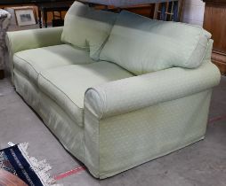 A two seater scroll arm sofa, with patterned green fabric loose covers, 190 x 95 x 80 cm high