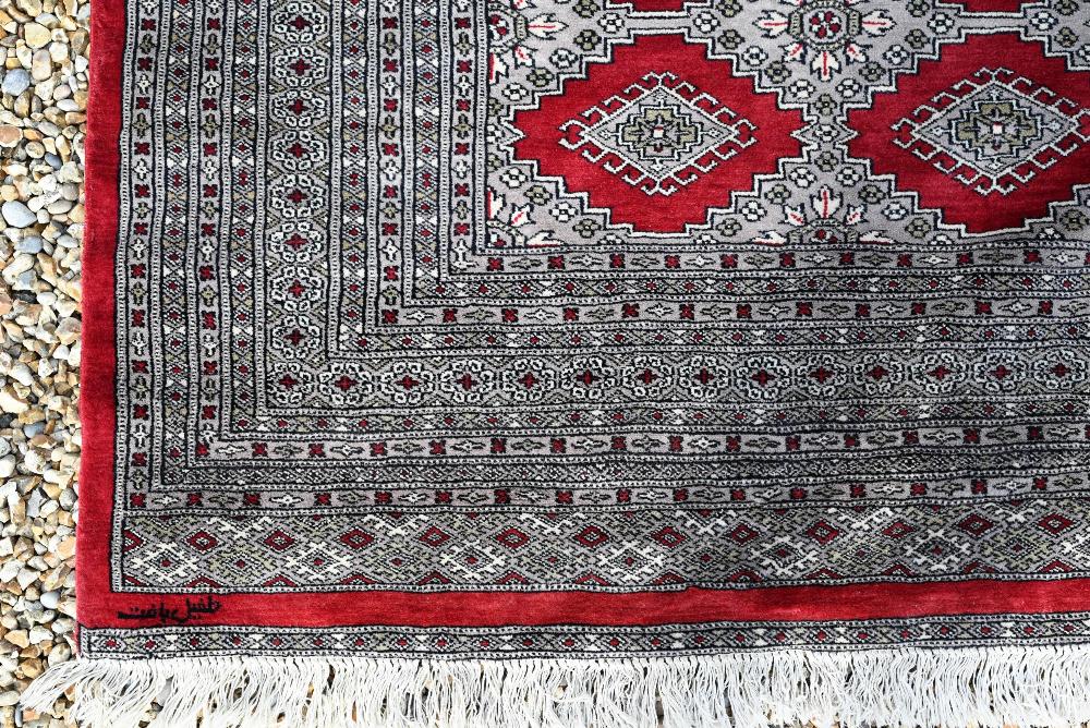 A large Pakistani Turkoman design carpet, red ground with repeating gul design and multi-borders, - Image 3 of 6