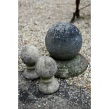 A weathered cast stone ball finial, 34 cm h to/with a pair of small ball finials (2)