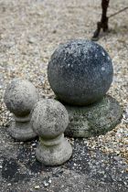 A weathered cast stone ball finial, 34 cm h to/with a pair of small ball finials (2)