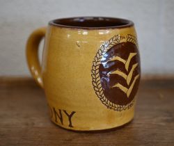 A slip-glazed earthenware mug decorated with Luftwaffe pilot's badge and inscribed 'Tony' 11 cm high
