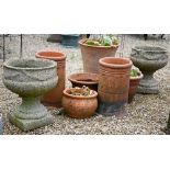 A pair of heavily weathered composite stone urn planters to/with an assortment of terracotta