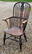 An elm seated wheelback Windsor elbow chair, turned supports and stretcher