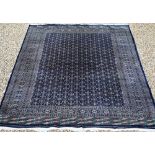 A large Pakistani Turkoman design carpet, the blue ground with repeating gul design and multi-