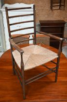 A antique ladder back open armchair with rope seat