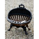 An old oval cast iron fire basket, raised on scroll feet, 40 cm w