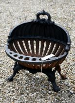 An old oval cast iron fire basket, raised on scroll feet, 40 cm w