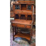 A 20th century Liberty style Arts & Crafts writing desk with leaded stained glass doors, three