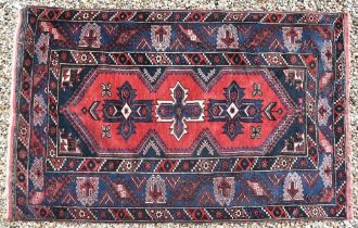 A Turkish Dosemealti red ground rug of geometric design, blue multi borders, 208 x 130 cm