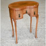 Edwardian walnut kidney shaped side table with three drawers, on pad footed cabriole supports, 52 cm