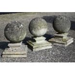 A trio of weathered diminutive ornamental pier top spheres on shaped plinths (3)