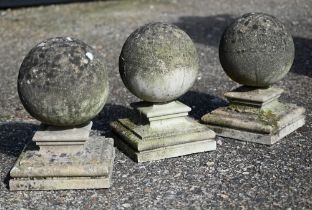 A trio of weathered diminutive ornamental pier top spheres on shaped plinths (3)