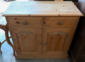 A waxed pine side cabinet with two drawers over panelled cupboards, 92 x 42 x 86 cm high