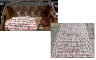 A large antique fabric panel, cross-stitched with religious texts within floral-printed surround,