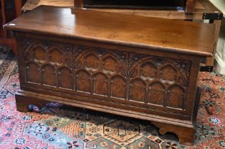 A 17th century style oak coffer with Gothic arch carved front and shaped bracket feet, 94 x 40 x