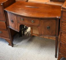 An antique small mahogany bowfront sideboard, centred by a drawer flanked by a deep drawer and