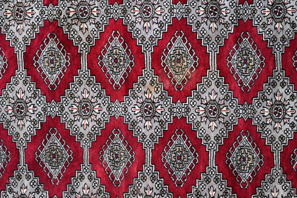 A large Pakistani Turkoman design carpet, red ground with repeating gul design and multi-borders, - Image 6 of 6