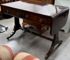 A Regency mahogany sofa table with two drawers, rectangular supports with splayed legs terminating