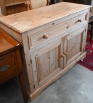 A pine side cabinet/dresser base with single drawer over panelled cupboard doors, 124 x 54 x 94 cm
