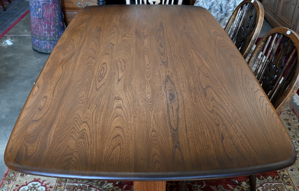 An Ercol dark elm dining table on twin-trestle supports united by the central stretcher, 150 cm x 84 - Image 3 of 3