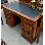 A late Victorian Aesthetic movement oak eight drawer desk with turned ebony handles and inset