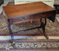 A Regency style mahogany sofa table with two drawers, lyre supports and brass paw castors, 90 x 55 x