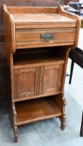 An Arts & Crafts golden oak stand with drawer, an open shelf and twin cupboard, 46 cm x 34 cm x