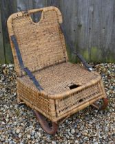 A vintage 1950s rattan wicker fishing chair with folding back supports by two leather straps