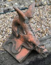 A reconstituted cast stone 'Brighton Dragon' ridge tile, aged terracotta finish, 44 cm high