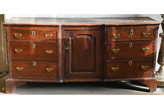 An 18th century oak inverted breakfront low dresser with central panelled cupboard with three - Image 1 of 8