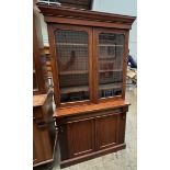 A Victorian mahogany bookcase with a moulded cornice above a pair of glazed doors,