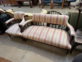 An Edwardian upholstered two seater settee together with an elbow chair with turned legs on casters