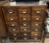 A stained beech filing cabinet with multiple drawers on casters