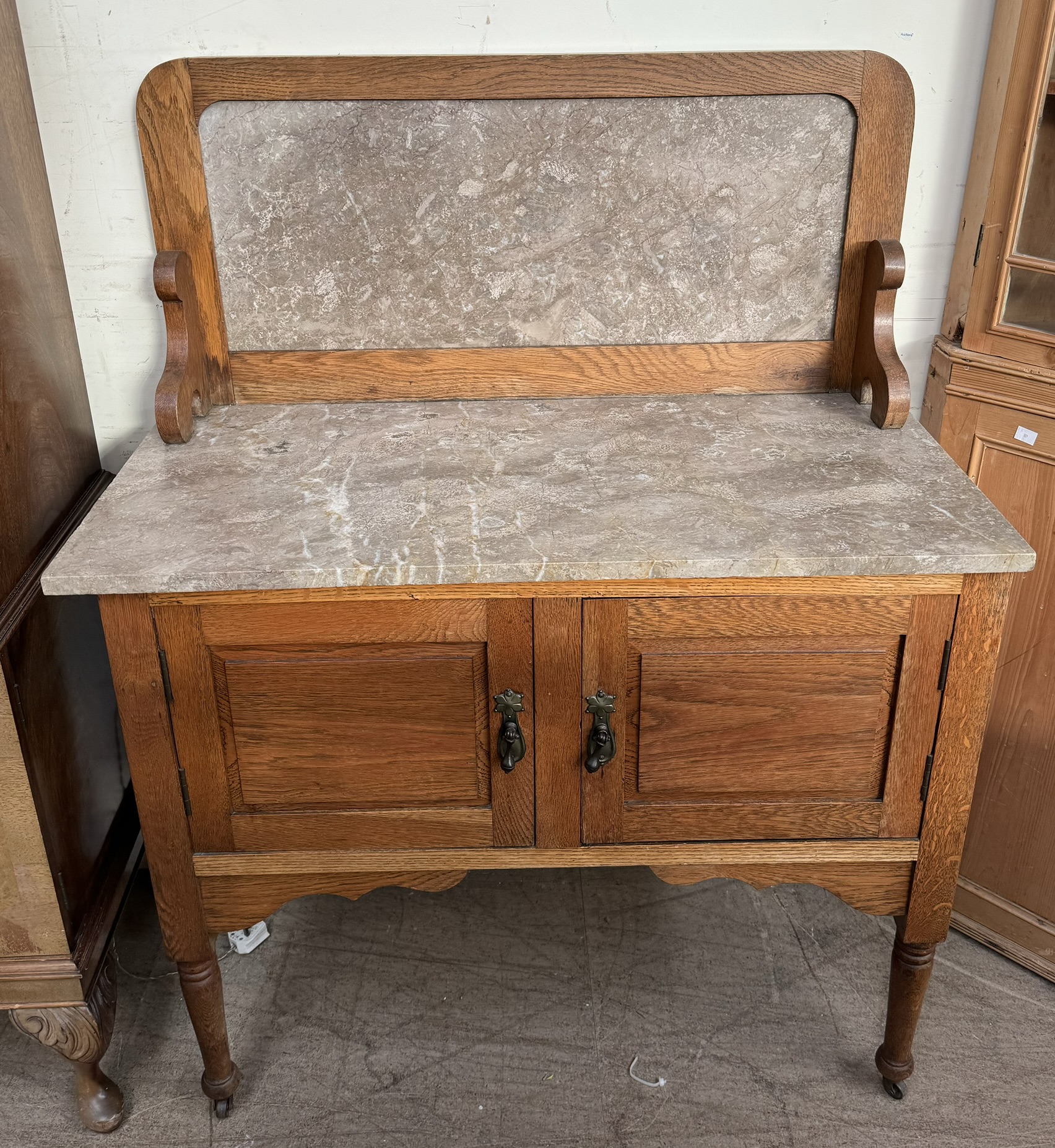 An Edwardian Marble top washstand with a pair of cupboard doors on turned legs