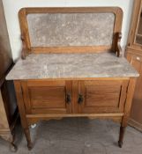 An Edwardian Marble top washstand with a pair of cupboard doors on turned legs