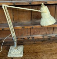 A cream and gold painted anglepoise lamp