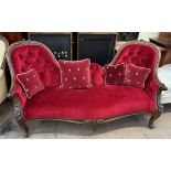 A Victorian walnut framed double chair back settee with plush red button back,